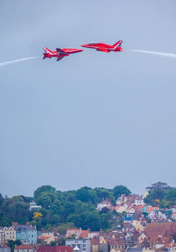 Two Red Arrows cross paths above St Peter Port Harbour