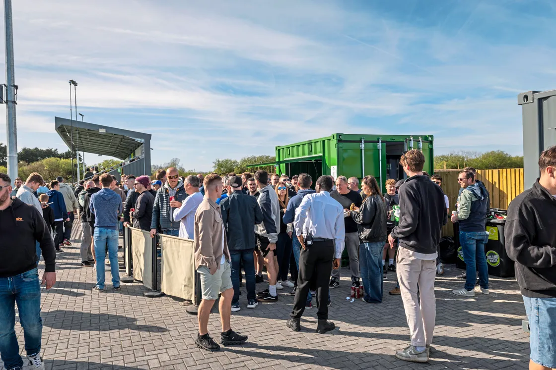 Supporters gathering at the pitchside drinks outlet.