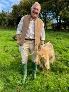 Sir Richard Cripwell with a Royal Golden Guernsey goat. 