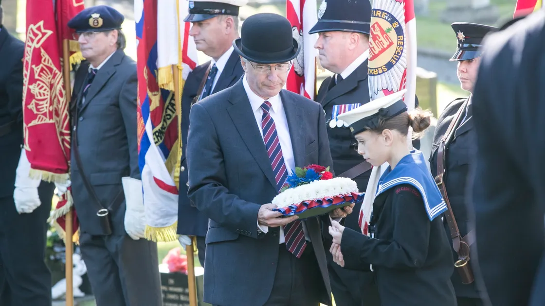 Pic by Adrian Miller 27-09-20 Foulon Cemetery. Remembrance service for H.M.S. Charybdis and H.M.S. Limbourne . Wreath Bearer Cadet Browning 13 of the Sea Cadets leads the Bailiff Richard McMahon. (28735069)