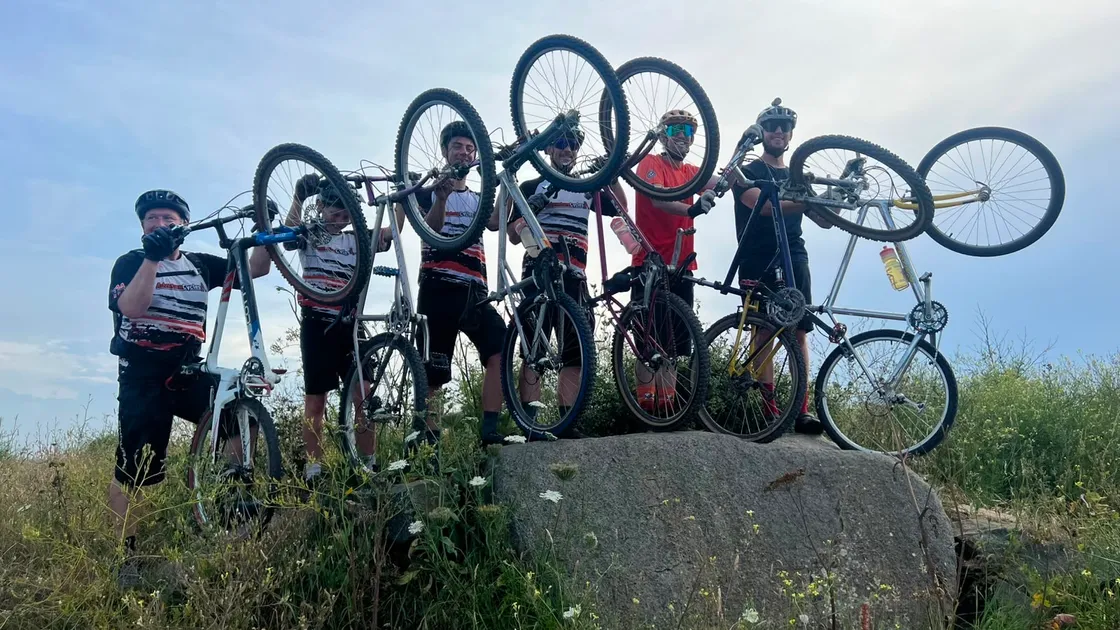 A group of cyclists on their warm-up ride showing off bikes that are at least 25 years old.