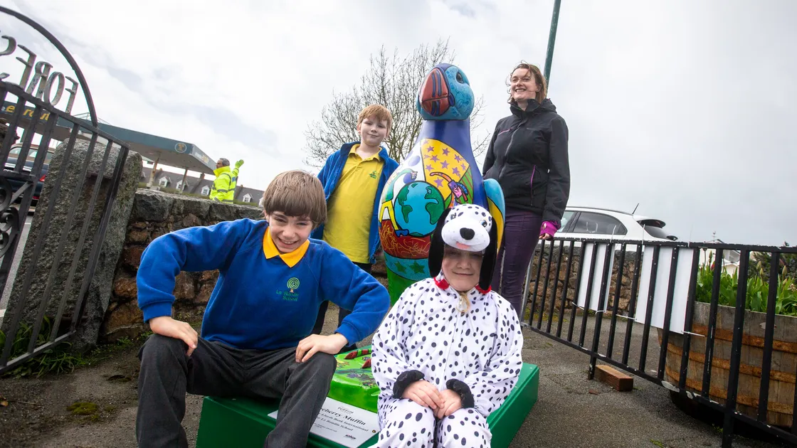 Blueberry Muffin, the ceramic puffin painted by Le Rondin School and sponsored by Lloyds Bank International, will be displayed outside Forest School as part of the parade. Sitting, left to right, are Wilson Teles, 9, and Freya Le Sauvage, 5. Behind them are Ollie Cambell, 10, and Le Rondin art teacher Lucy Brimage. (Picture by Luke Le Prevost, 31968362)