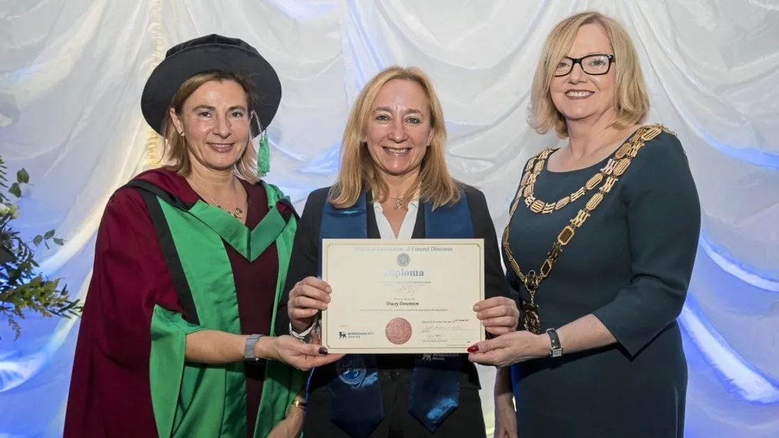 Tracey Dowinton, centre, receives her diploma.                             (20803844)