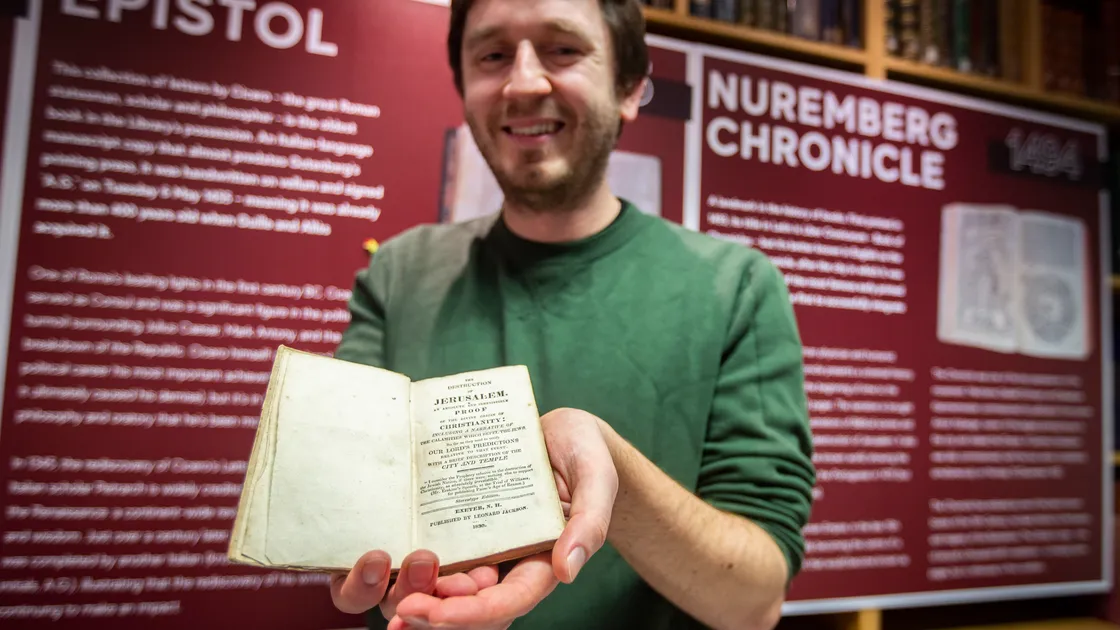 Adam Bayfield, head of marketing at the Guille-Alles Library, with one of the oldest books which has returned to its collection. Dutch librarian Garrelt Verhoeven bought this copy of The Destruction of Jerusalem online, but found Thomas Guille’s name inside and realised it used to be part of the Guernsey library, and returned it. (Picture by Sophie Rabey, 31643354)