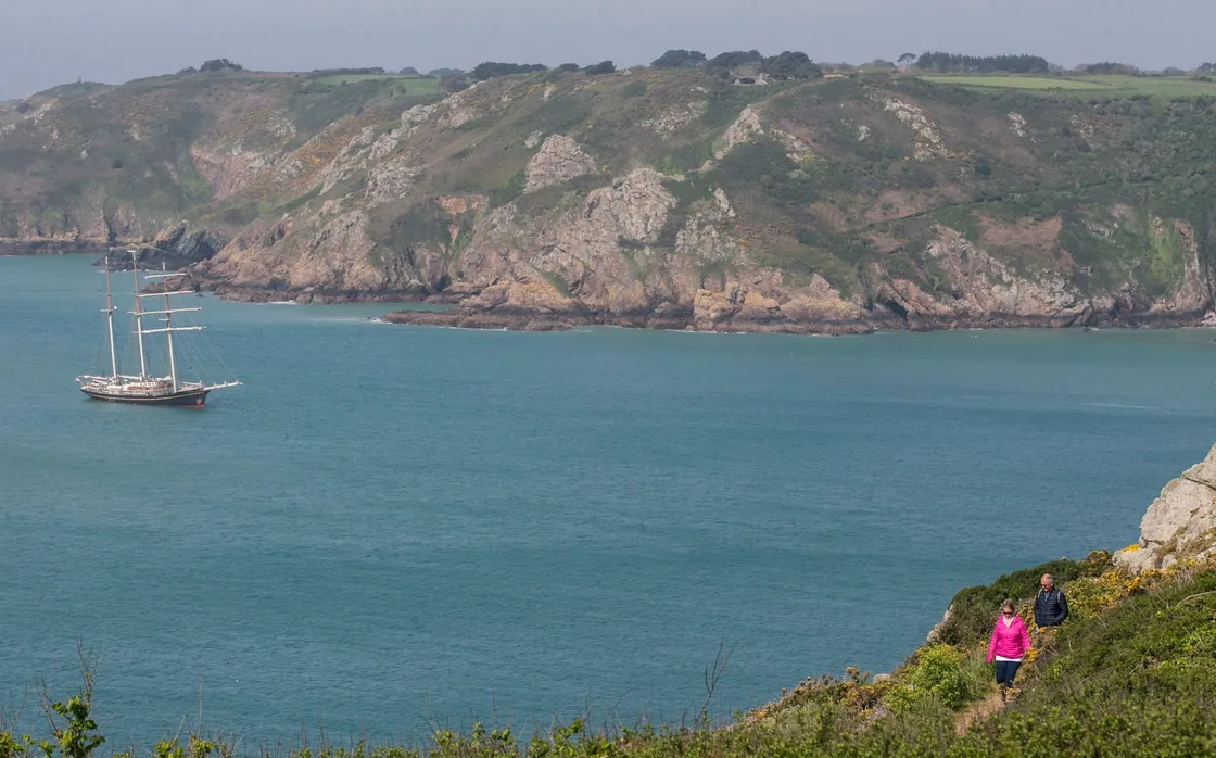 Pic by Adrian Miller 22-04-20 Icart Cliffs St Martin's south coast scenic with Gulden Leeuw schooner anchored up in background. Calendar. (28103024)
