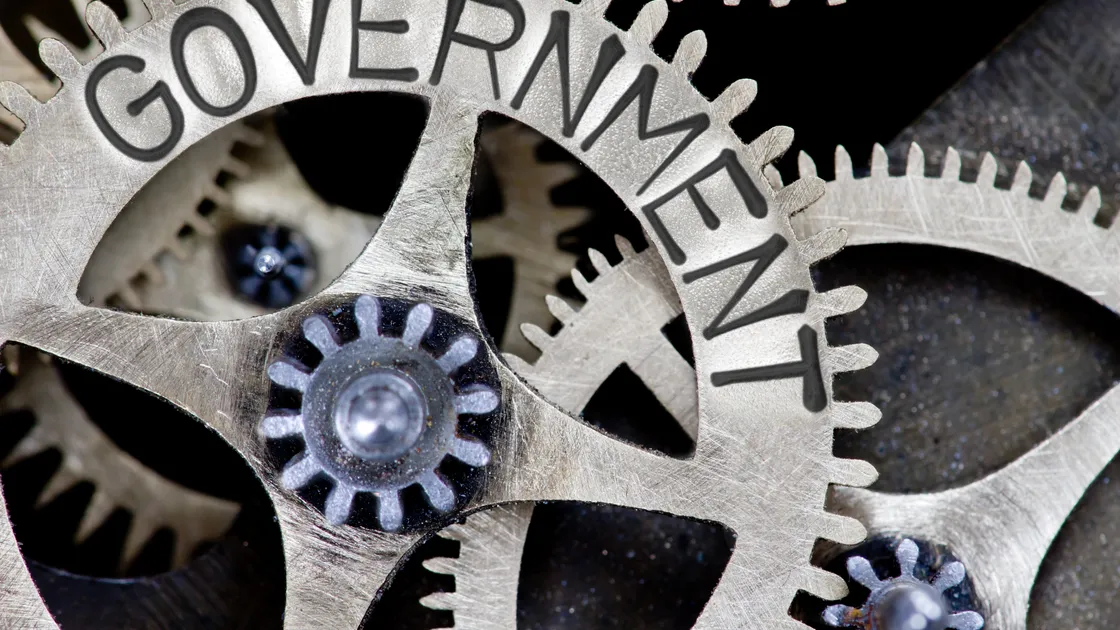 Macro photo of tooth wheel mechanism with GOVERNMENT letters imprinted on metal surface (32429285)
