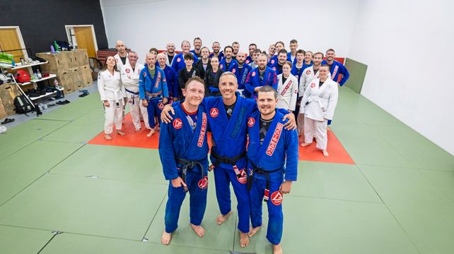 Two jiu-jitsu club members presented with black belts