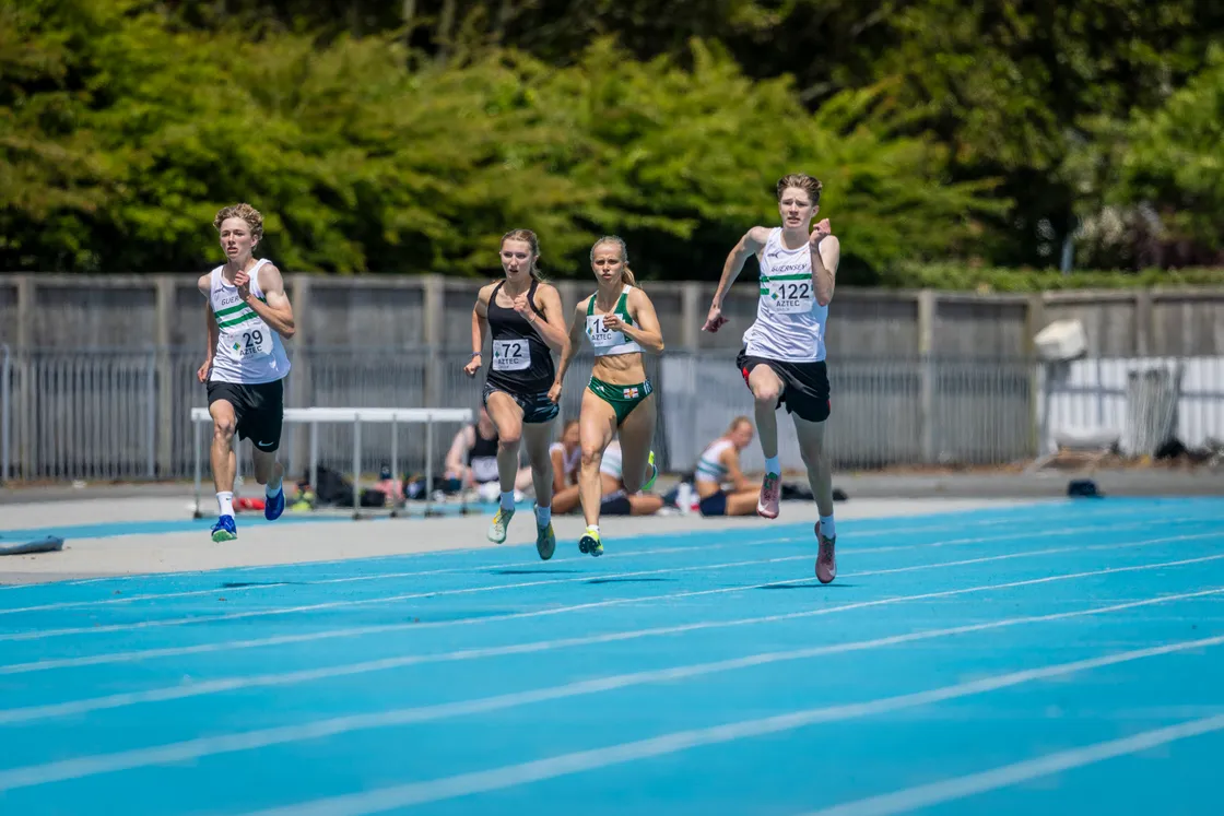 Amelie Van Heerden (72) duelling Abi Galpin (to her right) in the 200m.