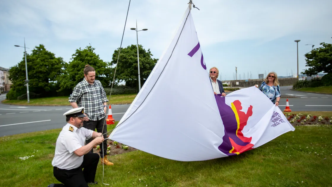 The Platinum Jubilee Flag for Guernsey, designed by competition winner Ben Le Marchant, was hoisted on the Weighbridge roundabout, with Sea Cadets commanding officer Lt Tony Browning lending his expertise. (Pictures by Luke Le Prevost, 30847504)