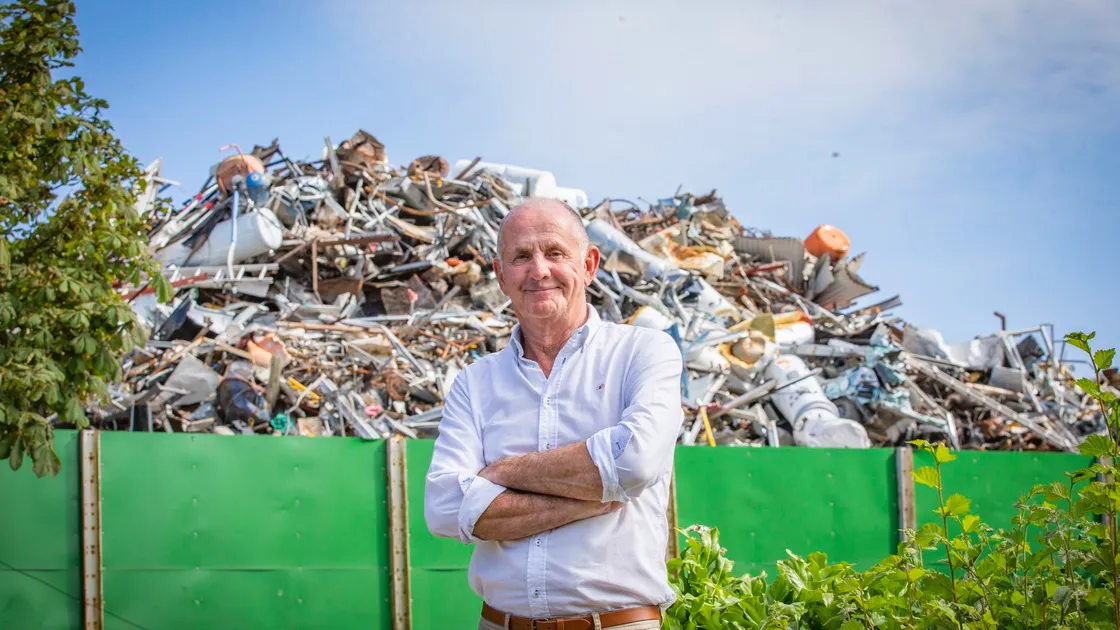 St Sampson’s douzenier Rob Gill, standing within St Sampson’s Church cemetery, is overshadowed by scrap metalfrom the recycling yard.  (Picture by Sophie Rabey, 29771397)
