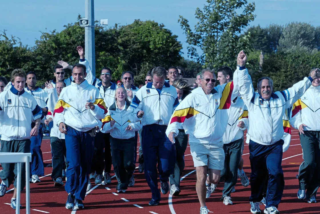 Rhodes' athletics team jogging around the Footes Lane track together with Sarnian athletes and coaches.