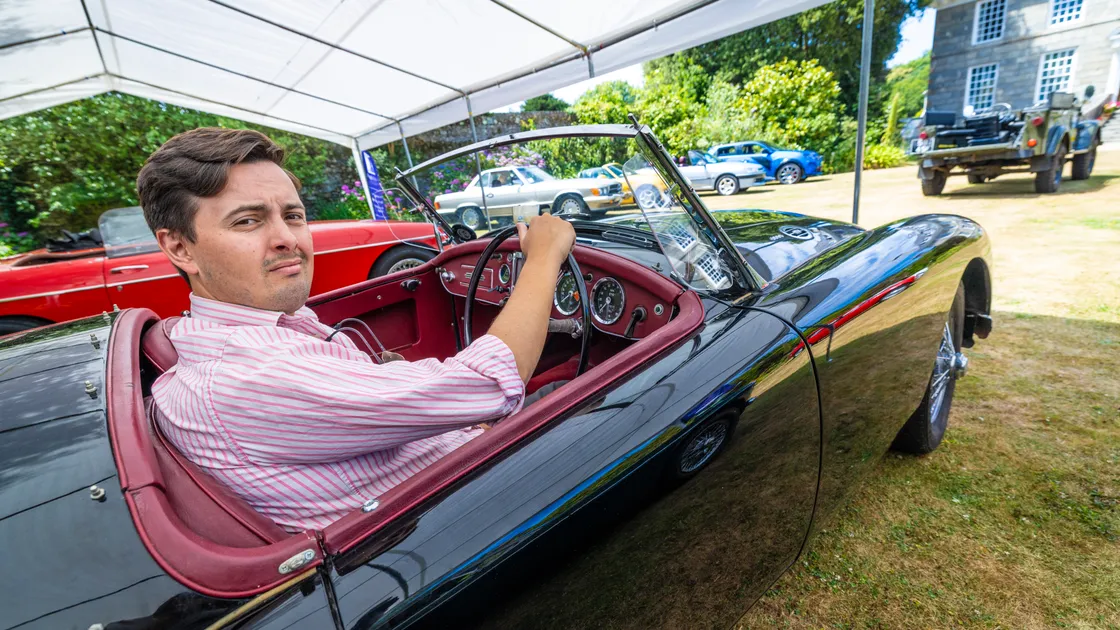 Guy Cooper of Martel Maides tries a 1959 MGA Roadster for size, one of the vehicles to be sold this Saturday.