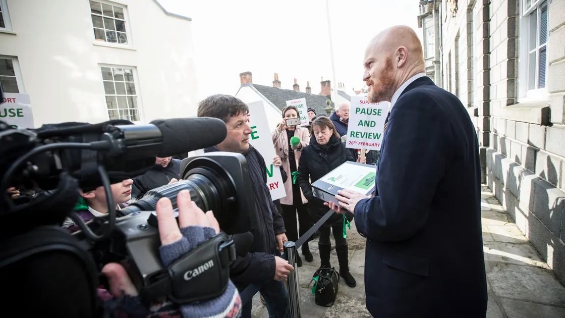 Pic by Adrian Miller 26-02-20.Royal Courts States.Protesters outside for Pause & Review.Petition organiser Mark Mauger hands over a petition to Gavin St Pier. (27288519)