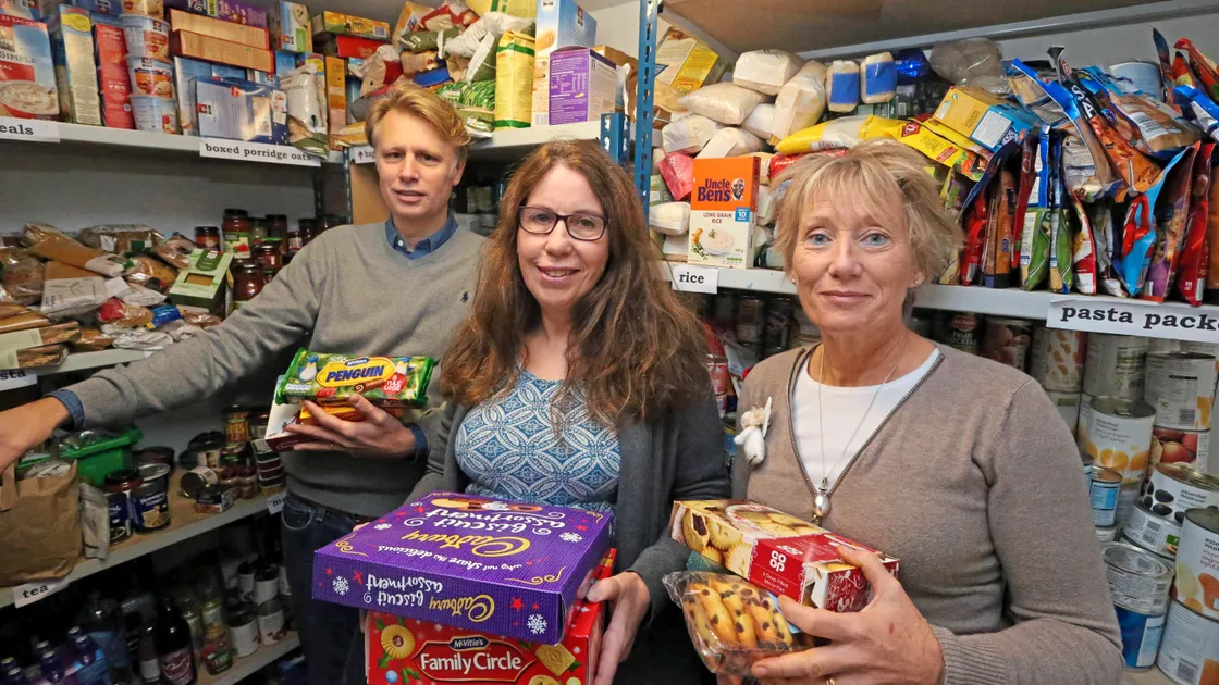 The main store for the Guernsey Welfare Service food bank is at Holy Trinity Church. Pictured with some of the items ready to be distributed in time for Christmas are the Rev. Jon Honour, the chairman of the GWS management team, and volunteers Sue Le Friec and Susi Glegg. (Picture by Steve Sarre, 20140052)