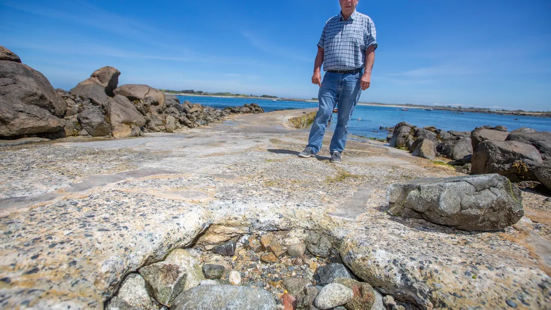 Vale junior constable Bill Cohu at Rousse Pier where a large hole has opened up. Local fishermen have filled the hole with rocks as a temporary fix. (Picture by Peter Frankland, 29659931)
