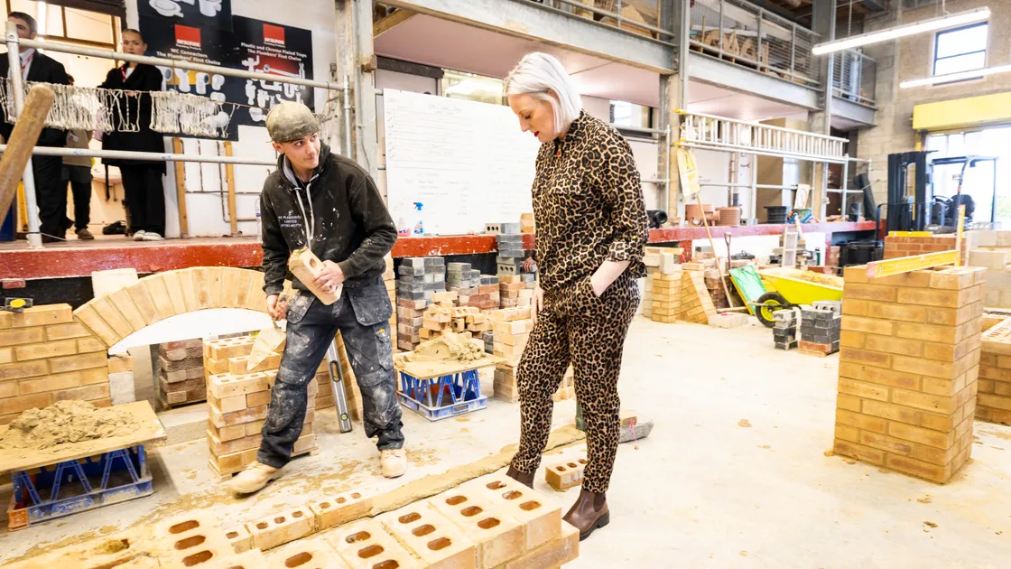 Steph McGovern, who started as an apprentice engineer at Black+Decker speaking to Level 2 student Kayden Carre, 17, who was completing some brickwork at The Guernsey Institute’s Coutanchez campus