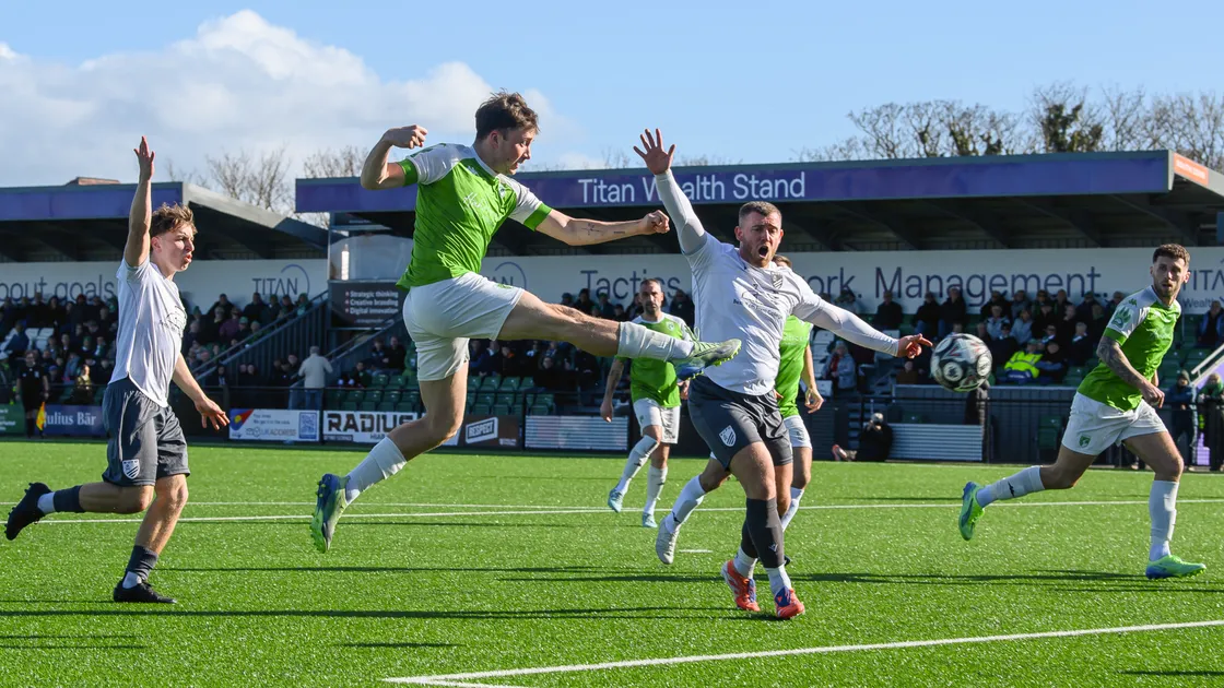 Bexhill United defenders appeal in vain as Cal Le Lacheur scores the winning goal for Guernsey FC.
