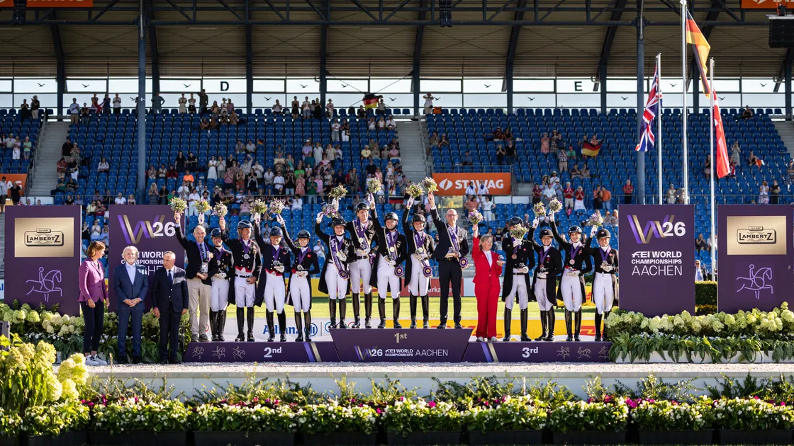 Carl Hester and the Great Britain dressage team on the podium having won silver at the 2026 FEI World Championships in Aachen on Wednesday. Germany won gold and Denmark took bronze.