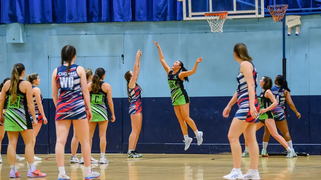 GK Erin Sullivan leaps up in an attempt to thwart a rangy shot from the Navy GS