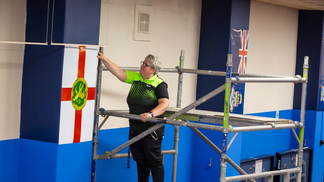 Guernsey table tennis development officer Becks O'Keefe putting up the flags of visiting islands ahead of the Island Games competition starting on Sunday. (Picture by Luke Le Prevost, 32267903)