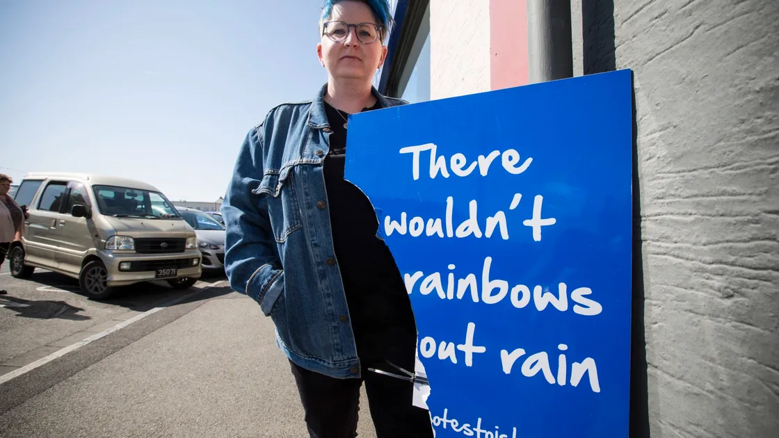 Artist Sian Jones alongside the most recently damaged Notes to Islanders sign, an exhibition she put on with Guernsey Mind and the Guernsey Arts Commission. She thinks this one was vandalised, but the weather has taken its toll on others. (Picture by Adrian Miller, 29473703)