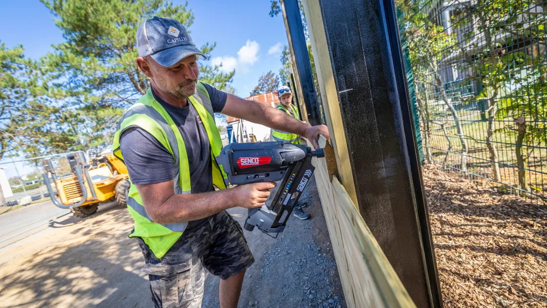 Left to right, Sam Ellis and Liam Staples of Infinity Construction building the acoustic fence that will protect Le Rondin School throughout the construction phase and from the new properties.
