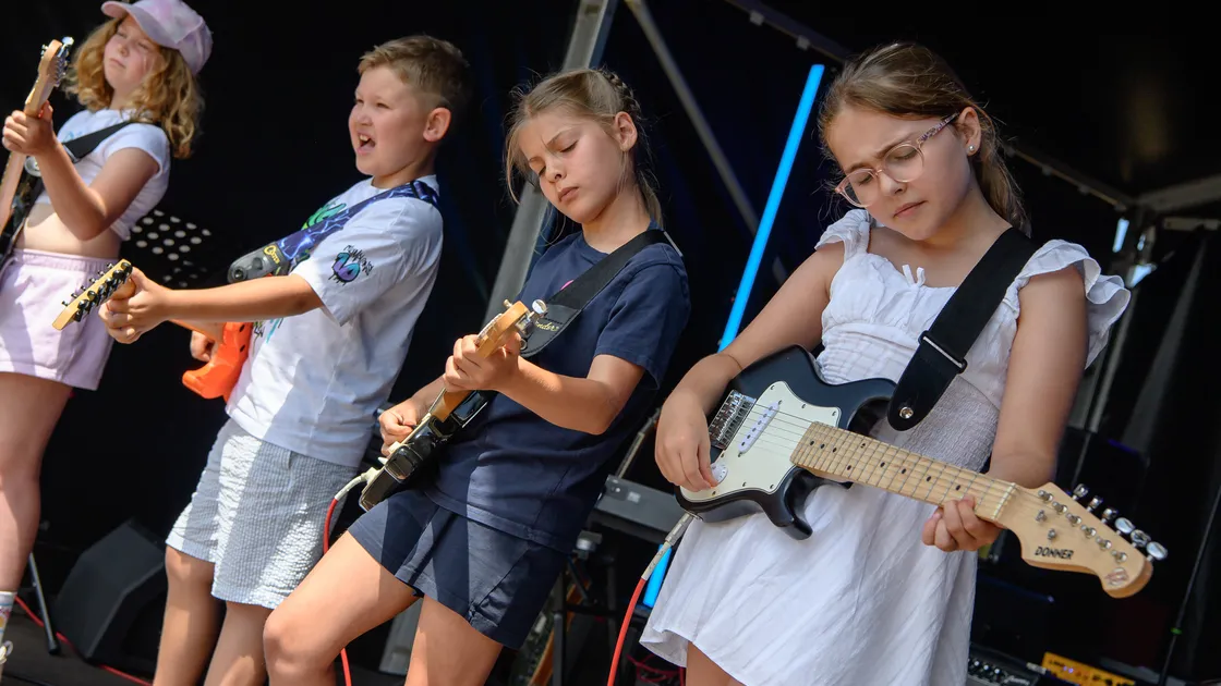 Plucky kids... Student guitarists have their turn on the stage.	