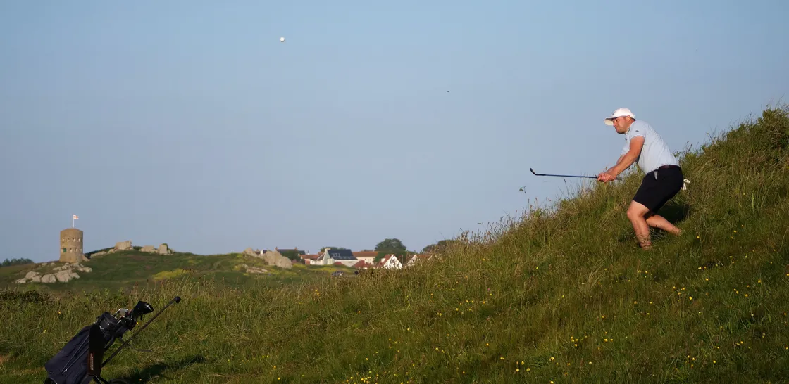 Sean Mills plays his second shot on the 18th from an unusual position on the side of the hill. (Picture by Gareth Le Prevost, 32154033)