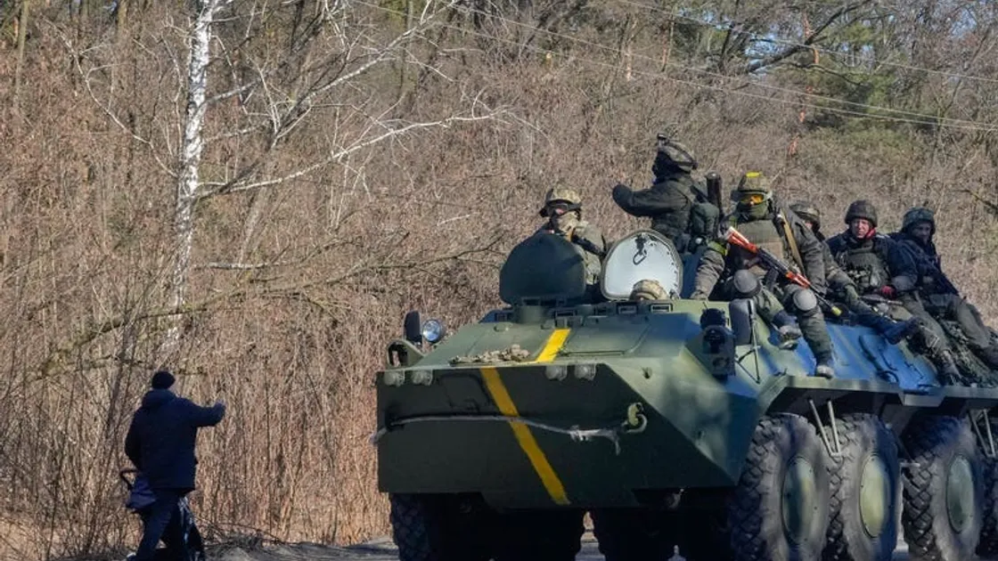 A man pushes a pram as he waves to Ukrainian soldiers on an armoured personnel carrier passing by in the Vyshgorod region close to Kyiv, Ukraine (30636483)