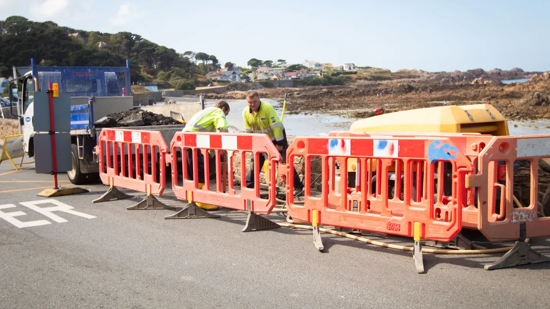 Workers assess the hole in Cobo Coast Road on Friday