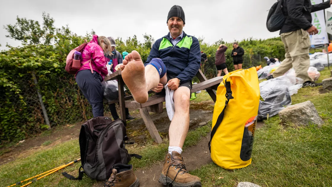 Jason Liddy changes his shoes at the Imperial checkpoint. 	