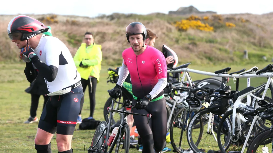 Race winner Dave Mosley, decked out in the distinctive pink kit of the Entire coaching group, leaves transition at Pembroke on Sunday morning to start his bike leg. (Picture by Adrian Miller, 29423570)