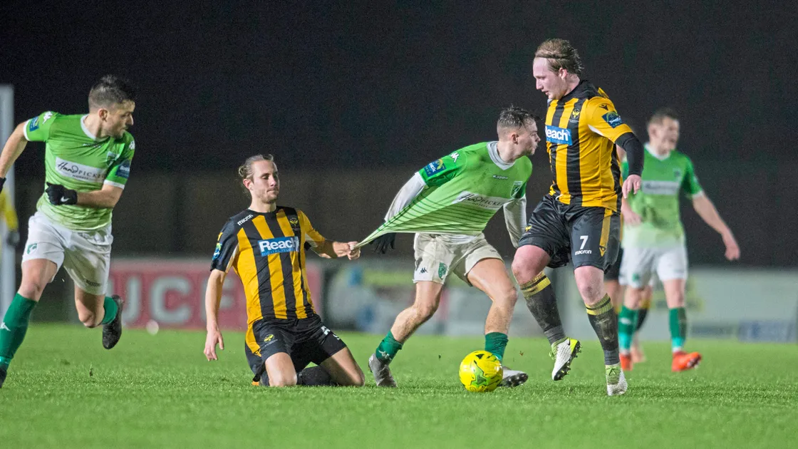 Ben Wilson pulls back Paris Pereira, who was making his 100th appearance for Guernsey FC last night at Footes Lane.  (Picture by Peter Frankland, 23829949)
