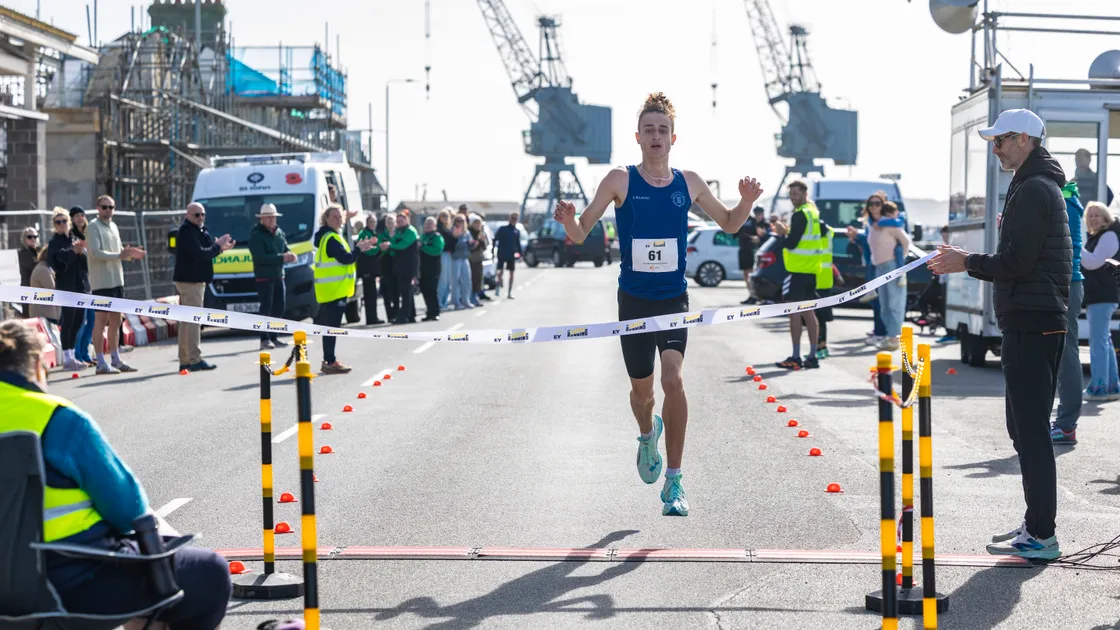 Bradley Andrews-Callec takes the tape to win the Grandes Rocques to Northside 10k road race yesterday, which also earned him the overall men's title at the festival.