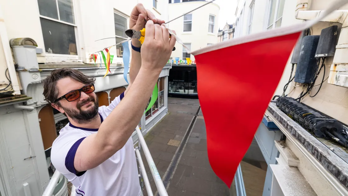 Alex Cross of Titan Wealth putting up bunting around town for the summer.