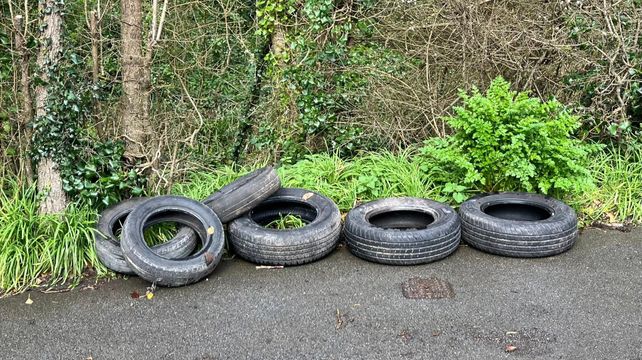 Car tyres are fly-tipped on a quiet road in Petit Bot valley
