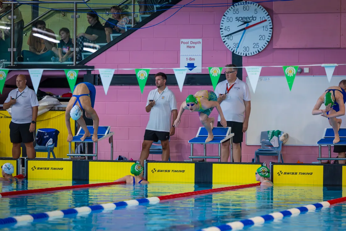 Every poolside vantage point is taken as Emma Bourgaize dives in.