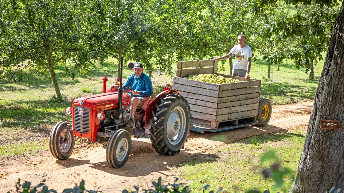 Graham Dorey helping out with his tractor while operations manager Miguel Gomes catches a ride