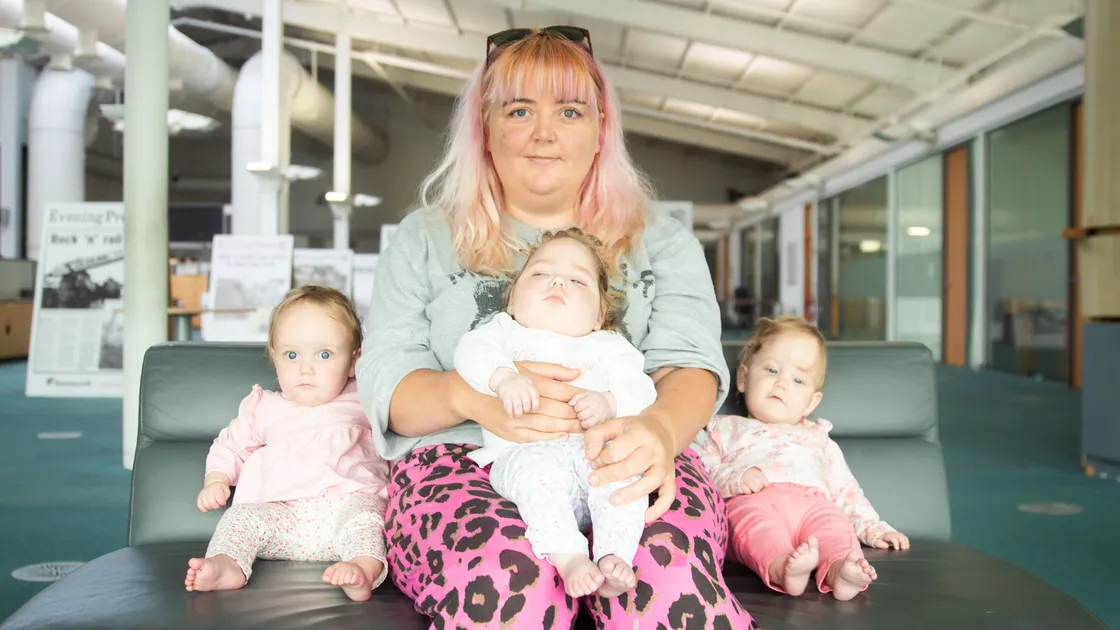 Margo, one of a set of identical triplets, was born with only 10% brain capacity and the family is hoping to fundraise £18,000 to pay for a stem cell treatment for her. Left to right, Aggie Brehaut, Margo Brehaut who is sat on her mother, Naomi Foley, and Edith Brehaut. (Picture by Erin Vaudin, 33572849)