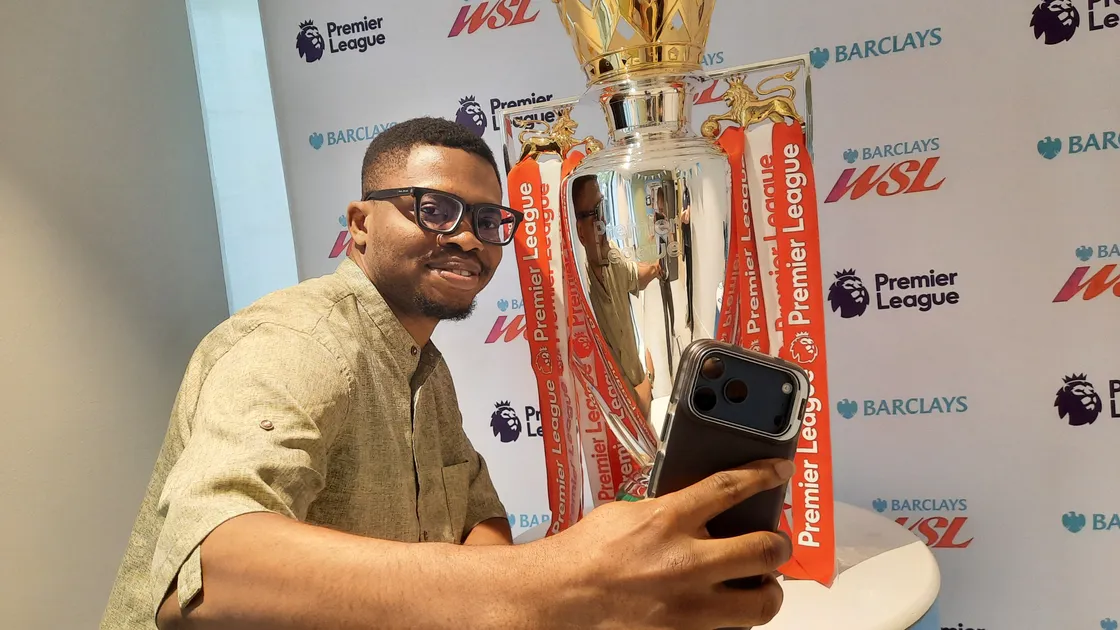 Arsenal fan Michael Matthew takes a picture of himself with the Premier League trophy.