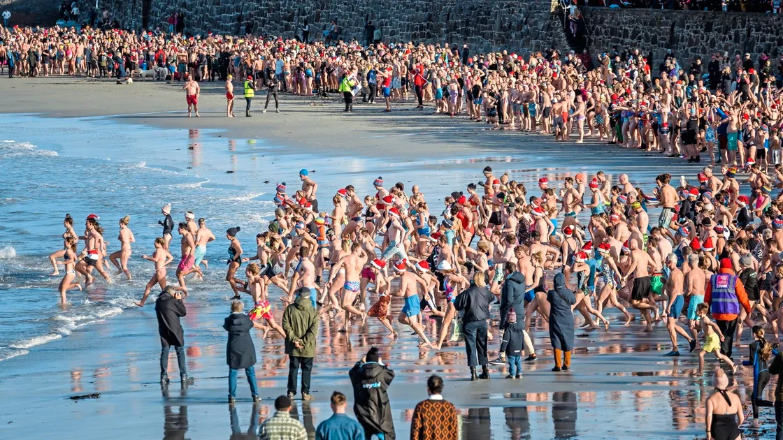 Swimmers rushing into the cold water at Cobo Bay in 2022. (32813581)