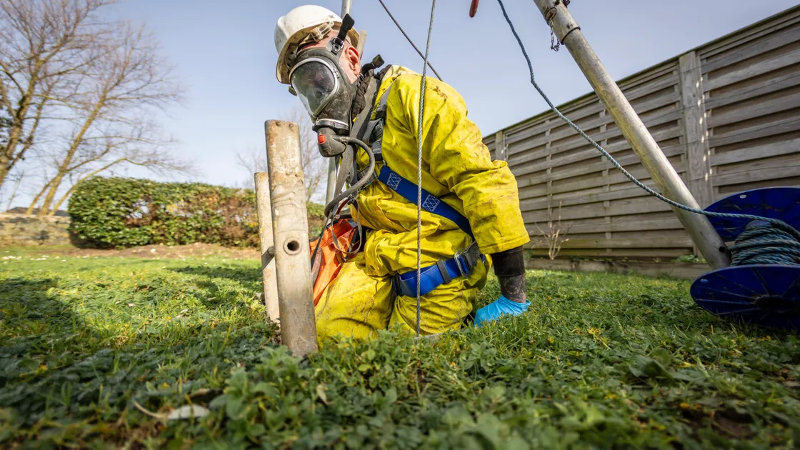 George De Carteret of Drain Away donning breathing apparatus and climbing into a cesspit to check for leaks