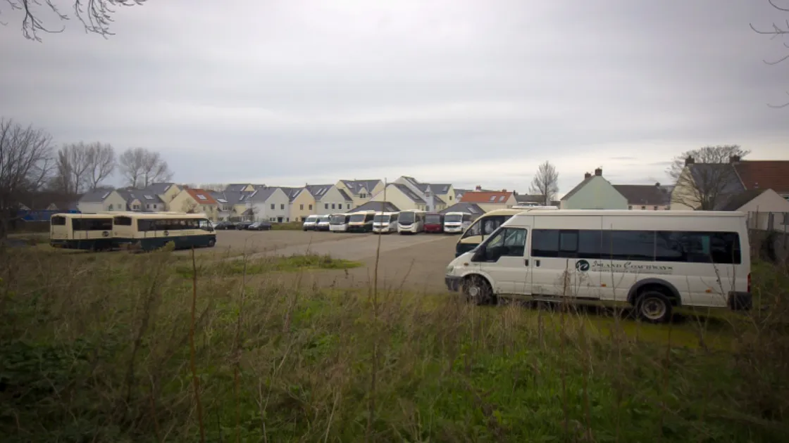 Buses and commercial vehicles parked on the former Bouet Estate site at Pitronnerie Road. (30371755)