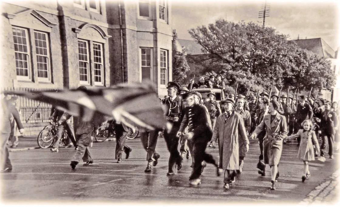  Bill de Carteret’s family has identified him as ‘the man in the flat cap’ in George Holt’s Liberation Day photograph.