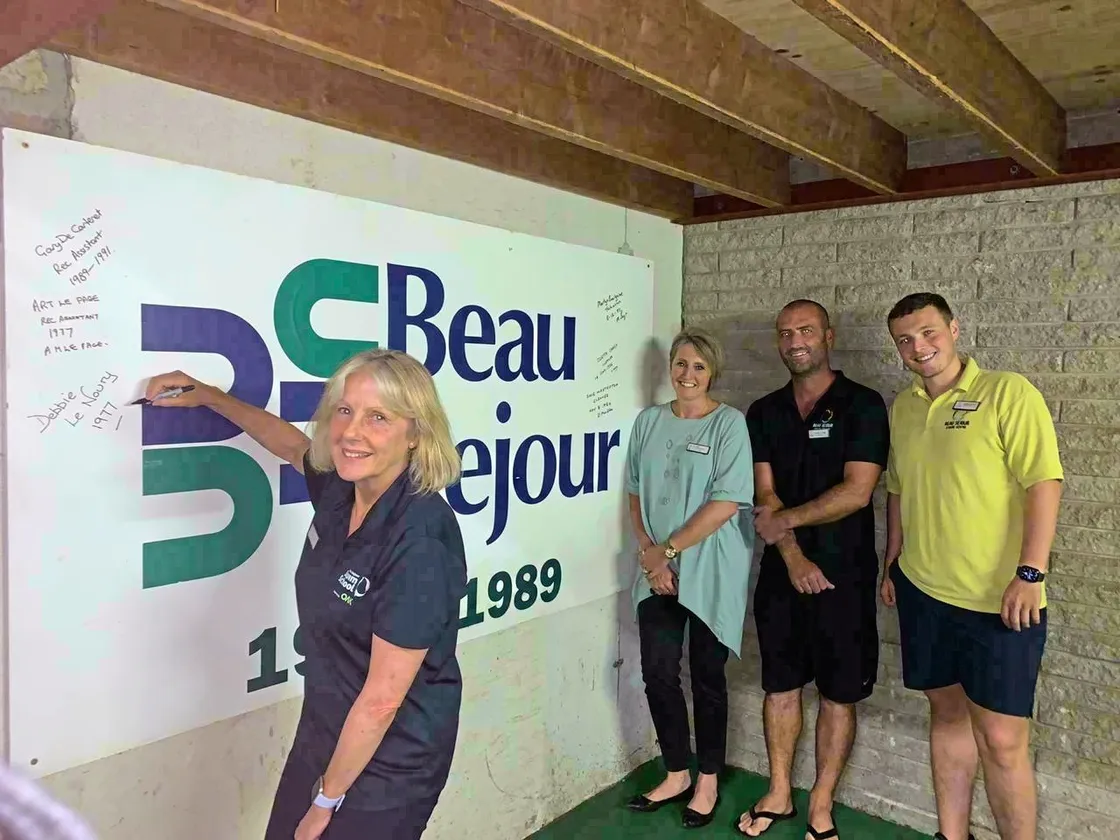 Left to right: Debbie Le Noury signing the board after starting work at Beau Sejour in 1977. She is pictured with Sam Herridge, Danny Le Page and Jordan James. Staff at the centre are asking past and present members of staff to come in and sign the board which has the date they first started working there. Picture by Zoe Fitch. (28512869)