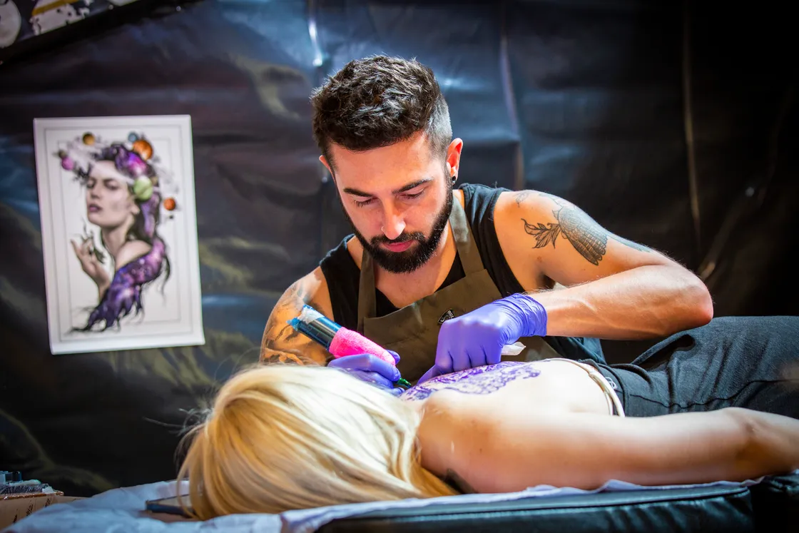 Concentration of the face of Adam Trump, from Ritual Tattoo Club, as he adds to Zoe Halton’s tattoos. (31018889)