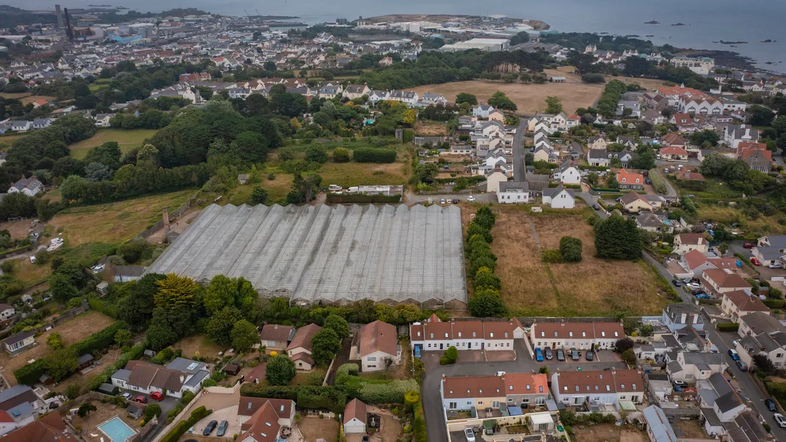 Peter Frankland’s picture of the site shows Delancey Park at the top with Pointues Rocques leading down, centre right, to a double bend and on eventually to St Clair Hill. The development site includes the area under glass.  (31080303)