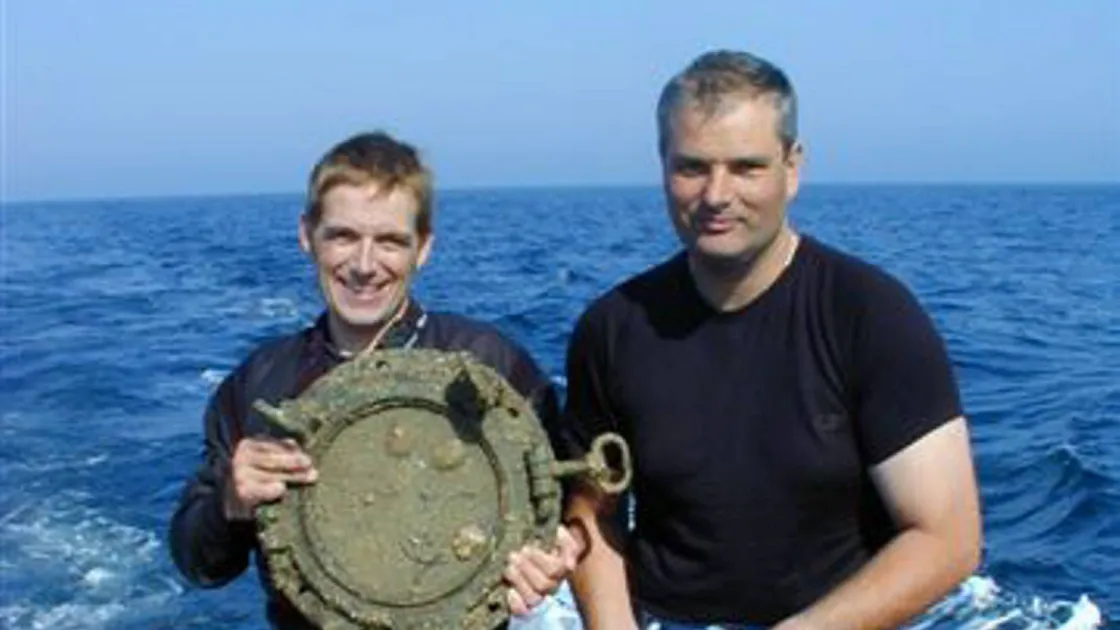 Divers Phil Warry, left, and Paul Carre with portholes recovered from the wreck of the St Malo back in 2006
