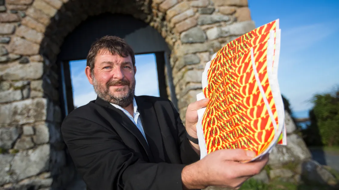 Vale Earth Fair collective member Rob Roussel holding entrance wristbands. It wants to sell early bird tickets for next year’s event to help clear a £10,000 debt. 
