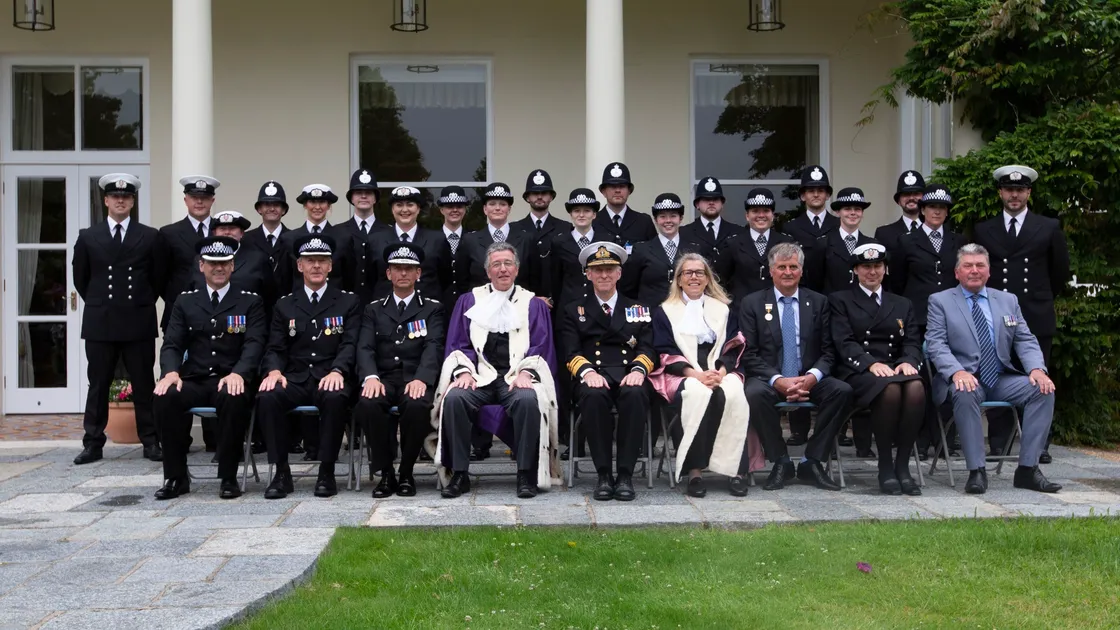 A formal photograph for the law enforcement classes of 2020 and 2021, standing, after their passing-out ceremony with senior officers and dignitaries, including Lt-Governor Vice Admiral Sir Ian Corder, Bailiff Richard McMahon, Deputy Bailiff Jessica Roland and Home Affairs president Deputy Rob Prow, seated in front of them.  (Picture by Cassidy Jones, 29682106)